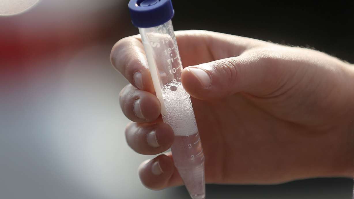 Eliza Herring holds a vial of her saliva for COVID-19 testing at an Intermountain Healthcare mobile testing site outside of Orem Community Hospital in Orem on Tuesday, Oct. 6, 2020.
