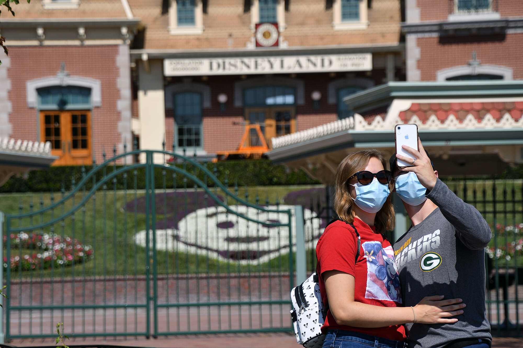 Alex Riedel takes a selfie with his wife, Jaime Riedel in front of the closed Disneyland Main Gate in Anaheim, CA, on Friday, Oct. 2, 2020.