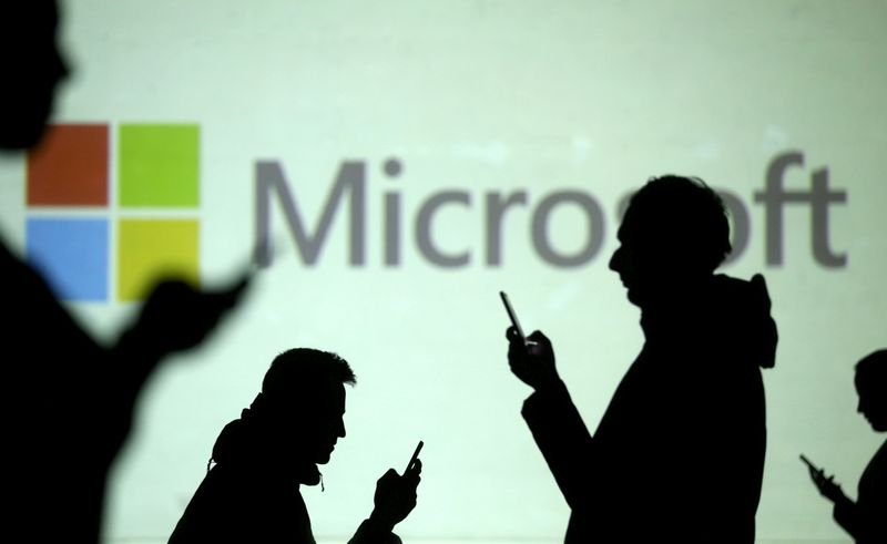 FILE PHOTO: Silhouettes of mobile users are seen next to a screen projection of Microsoft logo in this picture illustration taken March 28, 2018.  REUTERS/Dado Ruvic/Illustration/File Photo/File Photo