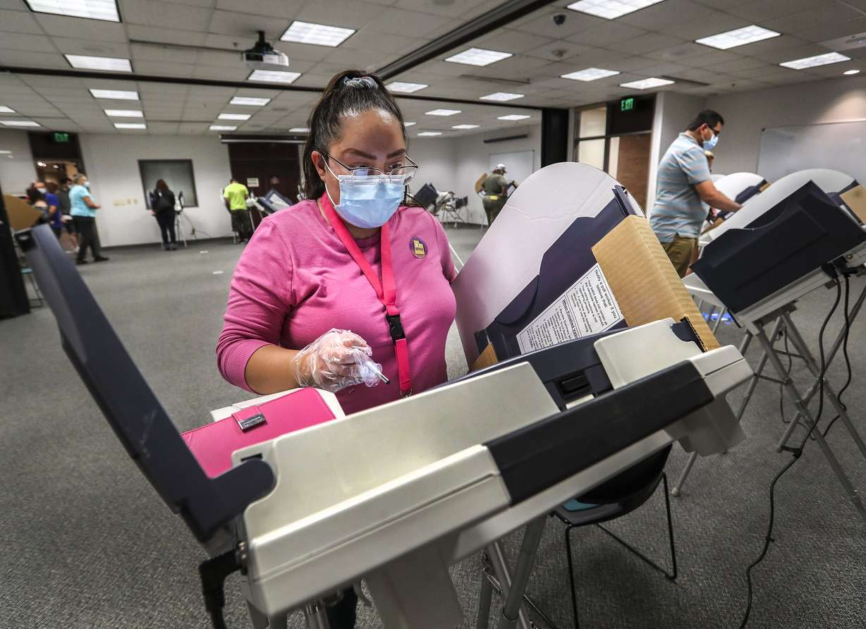 Elizabeth Winfrey, of Salt Lake City, joins other voters as she casts her ballot in person at the Salt Lake County Government Center during the first day of early voting in Utah on Tuesday, Oct. 20, 2020.