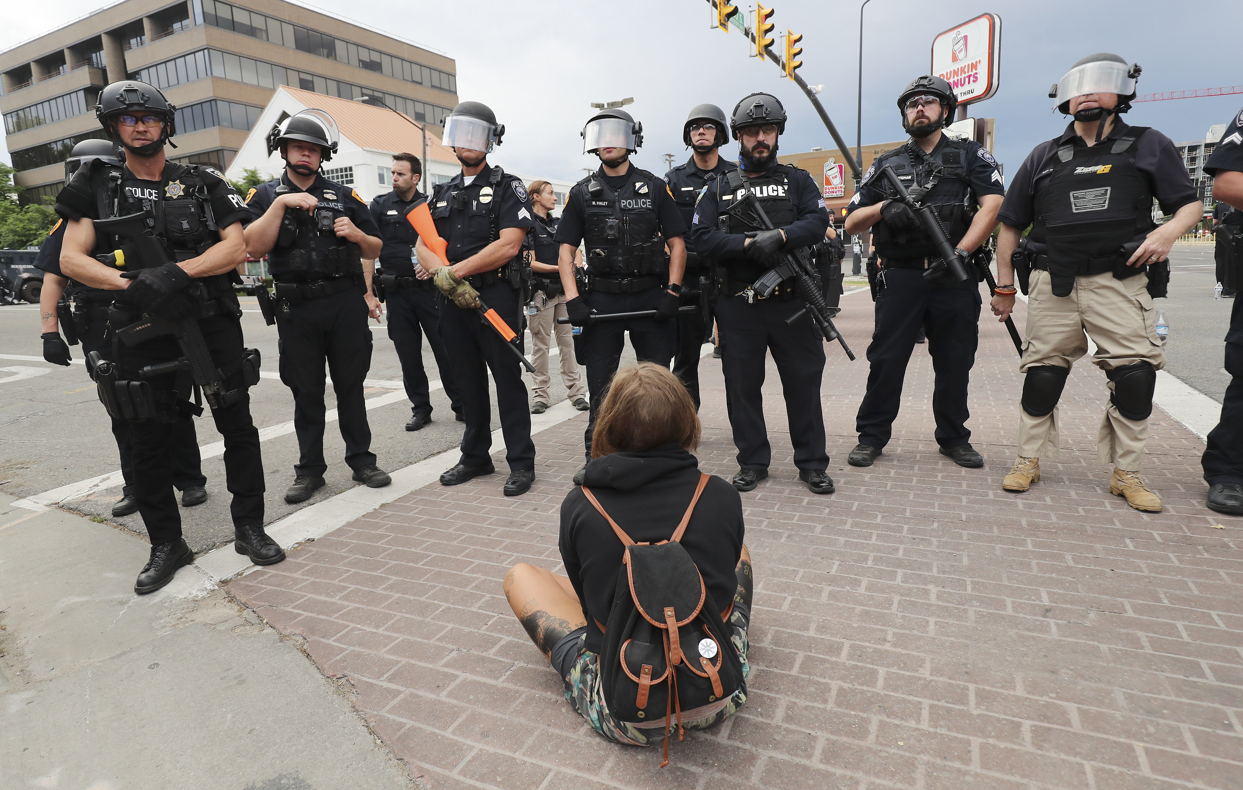 A protester sits alone in font of police during a protest against police brutality in Salt Lake City on Saturday, May 30, 2020. Protesters joined others across the nation to decry the death of George Floyd, a black man , who died while being taken into custody by police in Minneapolis earlier this week.