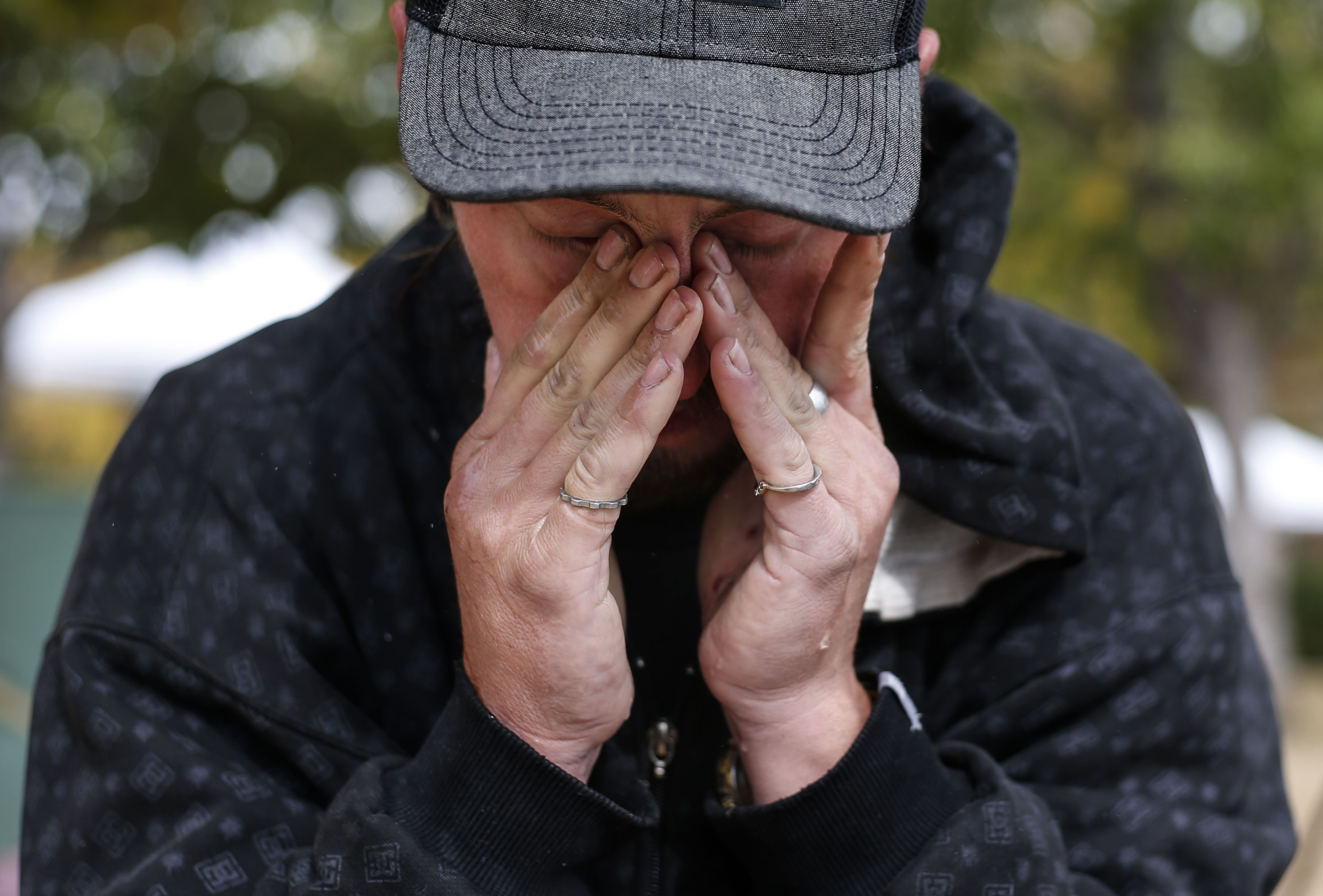 Christopher Hovey wipes his eyes after rinsing his face and hair with a bottle of water at Taufer Park in Salt Lake City on Friday, Oct. 23, 2020.