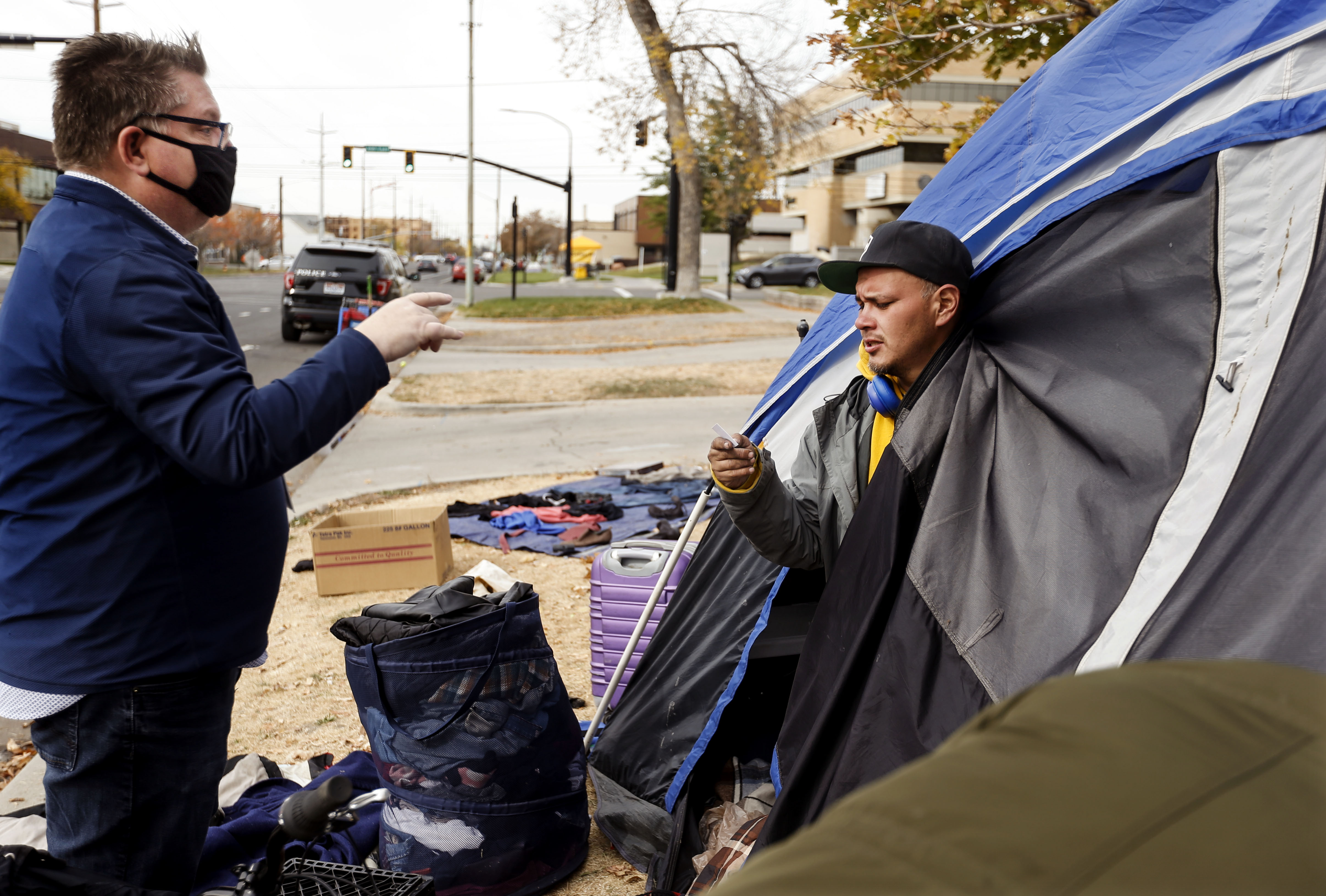 Mark Augustine, with the Salt Lake Legal Defender Association, gives his card to Luis Lopez at Taufer Park in Salt Lake City on Friday, Oct. 23, 2020. Augustine has helped Lopez with his legal needs in the past.