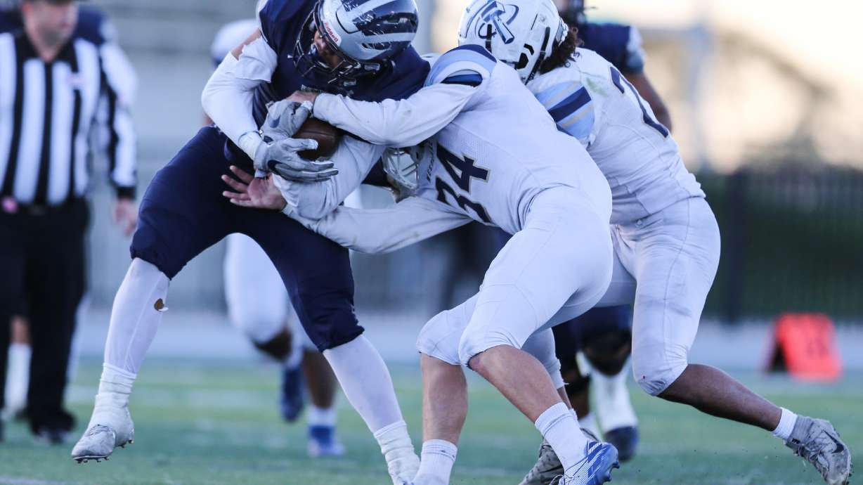 Hunter’s Lorenzo Tuaone (9) carries the ball against Westlake defense during a high school football playoff game at Hunter High School in West Valley City on Friday, Oct. 23, 2020.