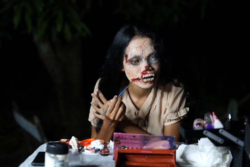 FILE PHOTO: Online clothes seller, Kanittha Thongnak, 32, applies zombie makeup before she starts livestreaming selling dead people's clothes in Bangkok, Thailand October 10, 2020. REUTERS/Jiraporn Kuhakan