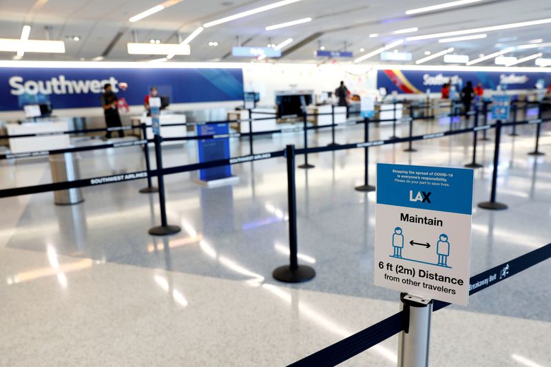 FILE PHOTO: Social distancing sign is displayed at a check-in area for Southwest Airlines Co. at Los Angeles International Airport (LAX) on an unusually empty Memorial Day weekend during the outbreak of the coronavirus disease (COVID-19) in Los Angeles, California, U.S., May 23, 2020. REUTERS/Patrick T. Fallon