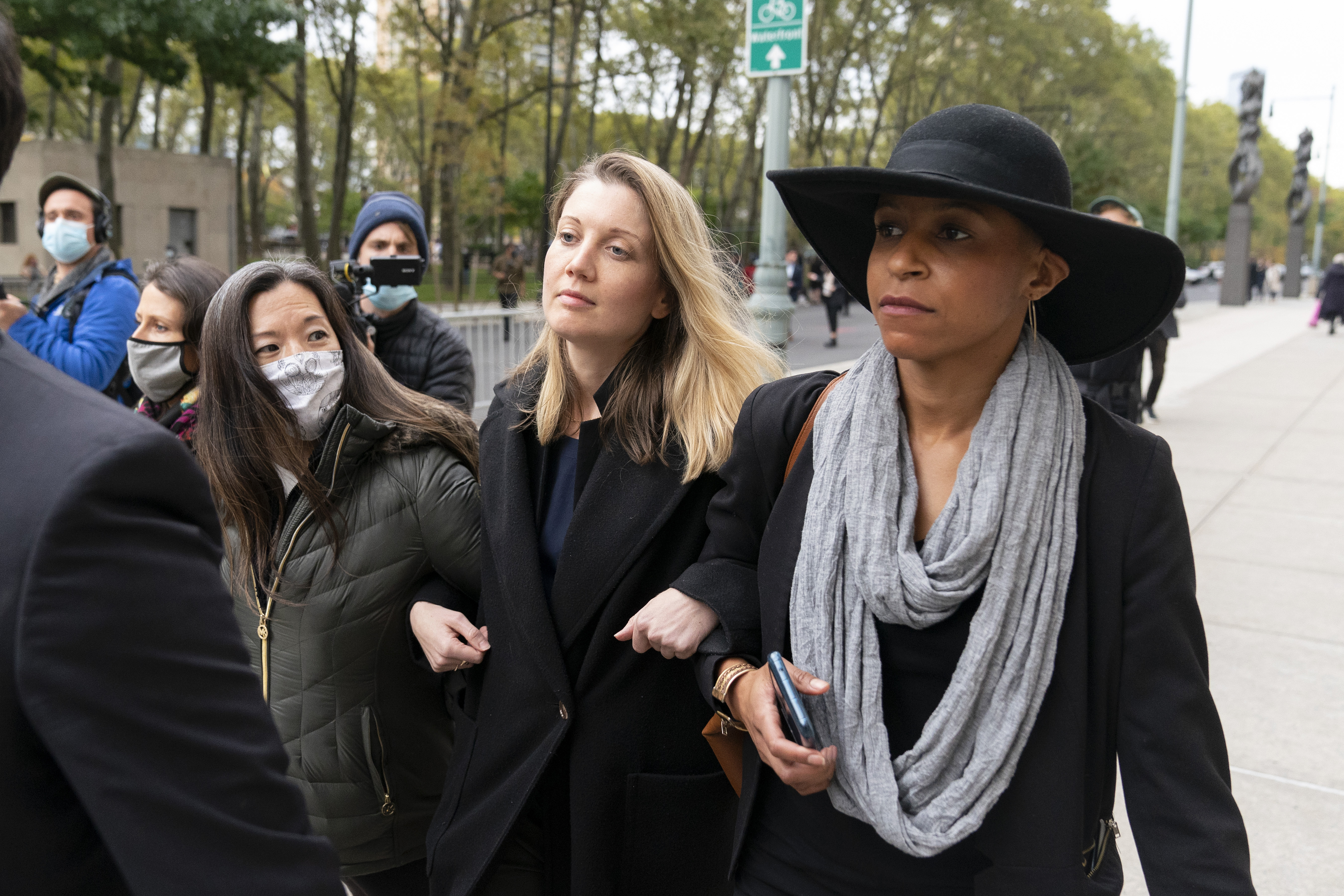 Linda Chung, left, Nicki Clyne, center, and Michelle Hatchette leave Brooklyn federal court following the sentencing hearing for self-improvement guru Keith Raniere, Tuesday, Oct. 27, 2020 in New York. Raniere, the NXIVM leader, was sentenced to 120 years.