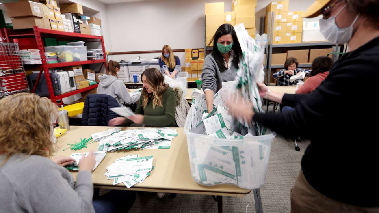 Workers go through every envelope making sure all the ballots have been taken out and counted at the Utah County Clerk/Auditor’s Office in Provo on Tuesday, Oct. 27, 2020.