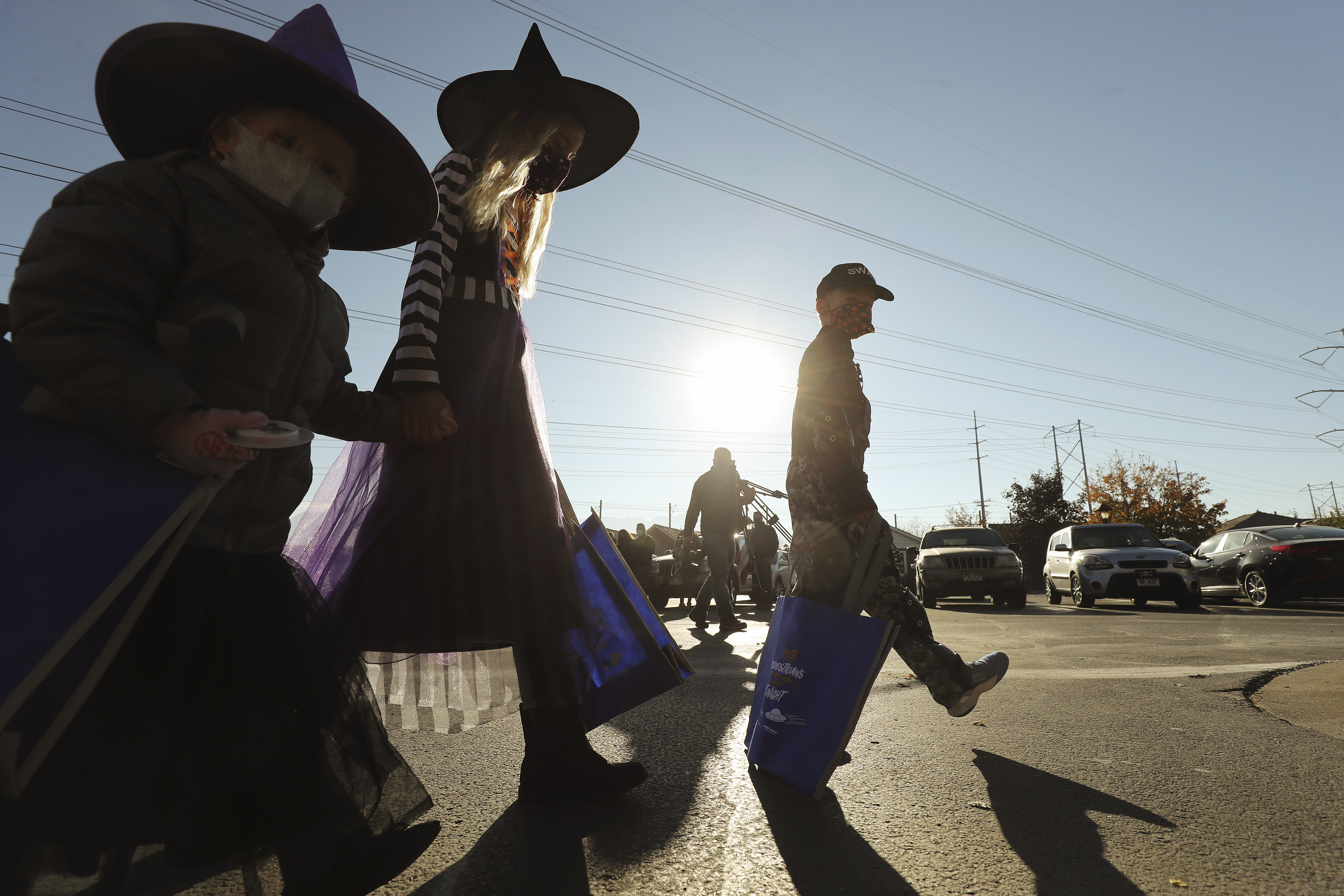 Mattie Robbins, left, Mary Allen and Johnny Allen walk with reflective bags and while wearing reflective costumes at Gardner Village in West Jordan on Wednesday, Oct. 28, 2020, as the Utah Department of Public Safety and the Utah Department of Transportation unveil the "Driver Myths" campaign to help improve pedestrian safety. Pedestrian fatalities tend to increase during Halloween and daylight saving time.