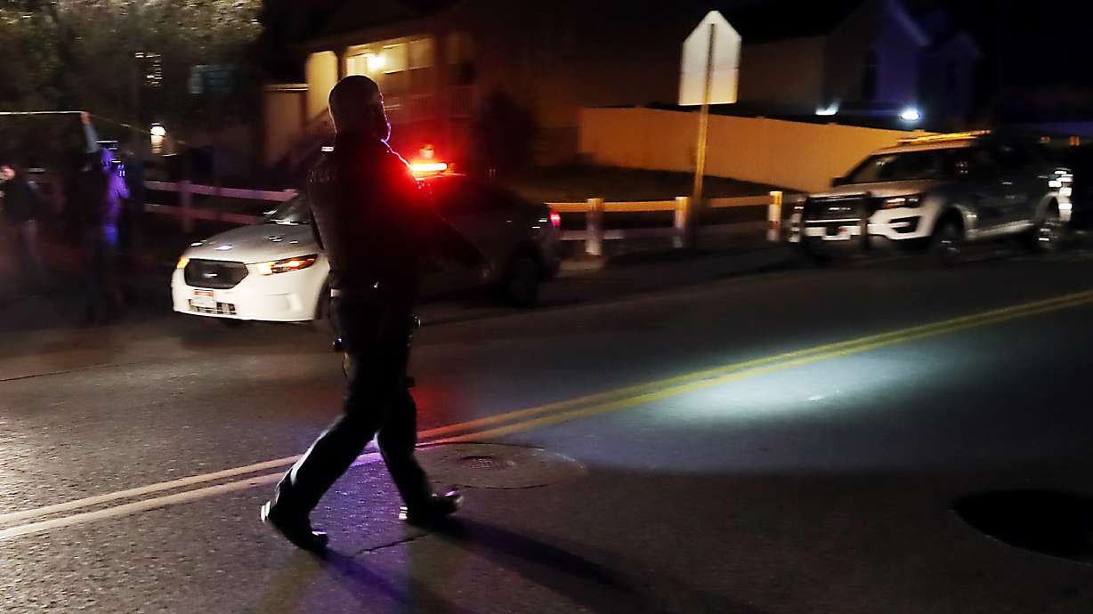 A Unified police officer walks in the street motioning to traffic at the scene of a domestic violence homicide at 115 W. Settlement Circle In Midvale on Wednesday, Oct. 28, 2020.