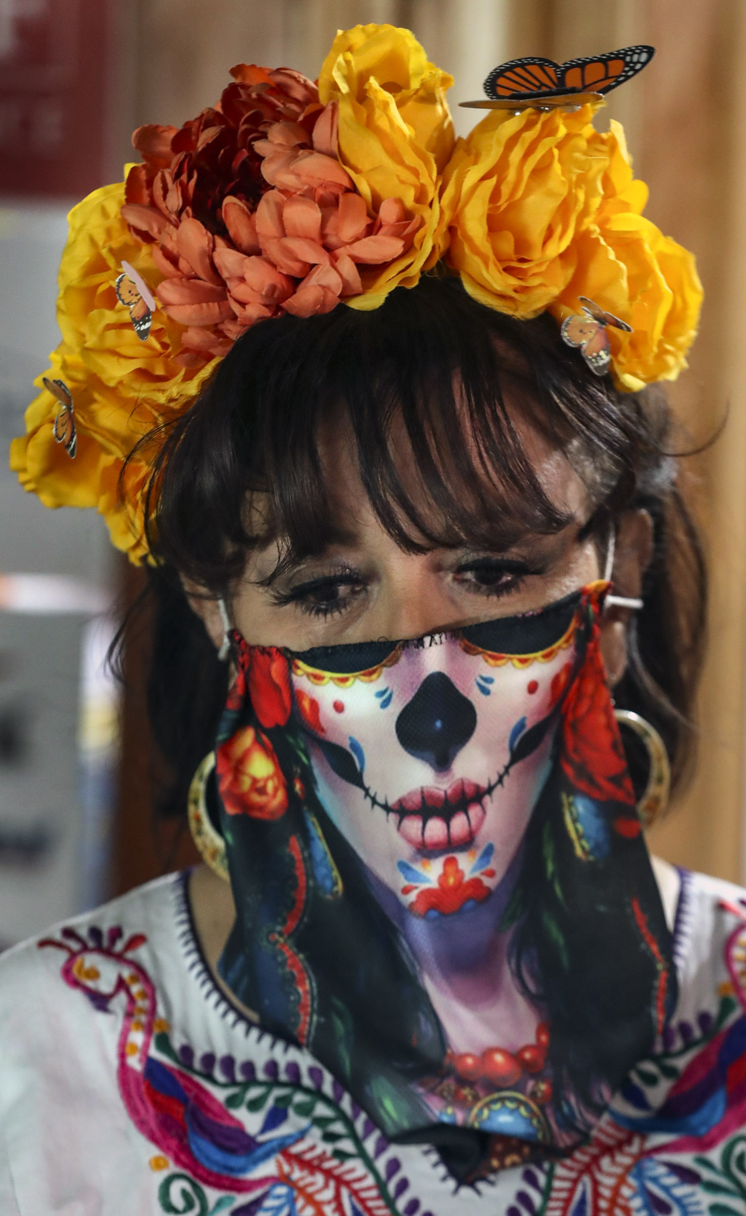 Rocio Mejia, director of Una Mano Amiga, listens as artist Marla O. Lepe talks about family and friends who have died and are represented in Una Mano Amiga's Day of the Dead window display at Trolley Square in Salt Lake City on Wednesday, Oct. 28, 2020. This year, because of COVID-19, the organization designed the special social distancing window honoring family members, friends, first responders and others who died of the virus.