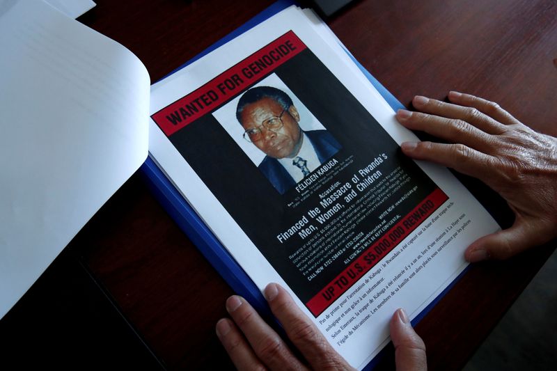 FILE PHOTO: Eric Emeraux, head of the Gendarmerie's Central Office for Combating Crimes Against Humanity, Genocides and War Crimes (OCLCH), displays documents with a wanted poster depicting a photograph of Felicien Kabuga during an interview with Reuters at his office, about the arrest of Rwandan genocide fugitive suspect Felicien Kabuga, in Paris, France, May 19, 2020. REUTERS/Benoit Tessier