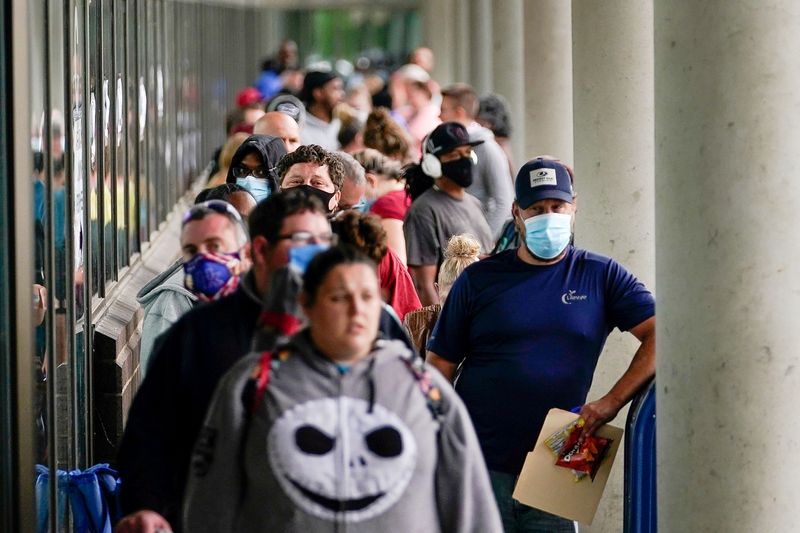 FILE PHOTO: Hundreds of people line up outside a Kentucky Career Center hoping to find assistance with their unemployment claim in Frankfort, Kentucky, U.S. June 18, 2020. REUTERS/Bryan Woolston