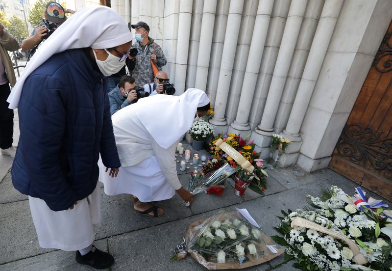 Nuns put flowers in tribute to the victims of a deadly knife attack at the Notre Dame church in Nice, France, October 30, 2020. REUTERS/Eric Gaillard
