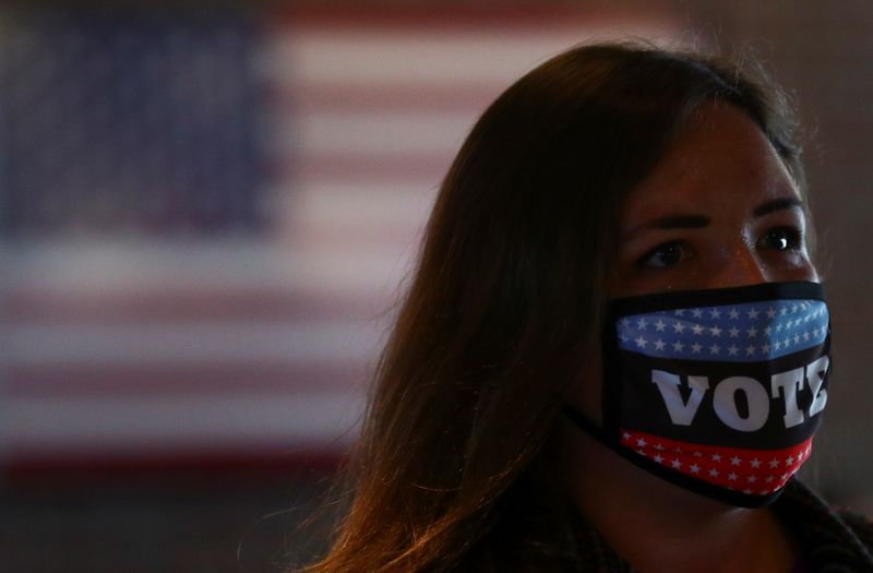 A woman wears a "Vote" face mask at an early voting station at the Nationals Park in Washington, U.S., October 30, 2020. REUTERS/Hannah McKay