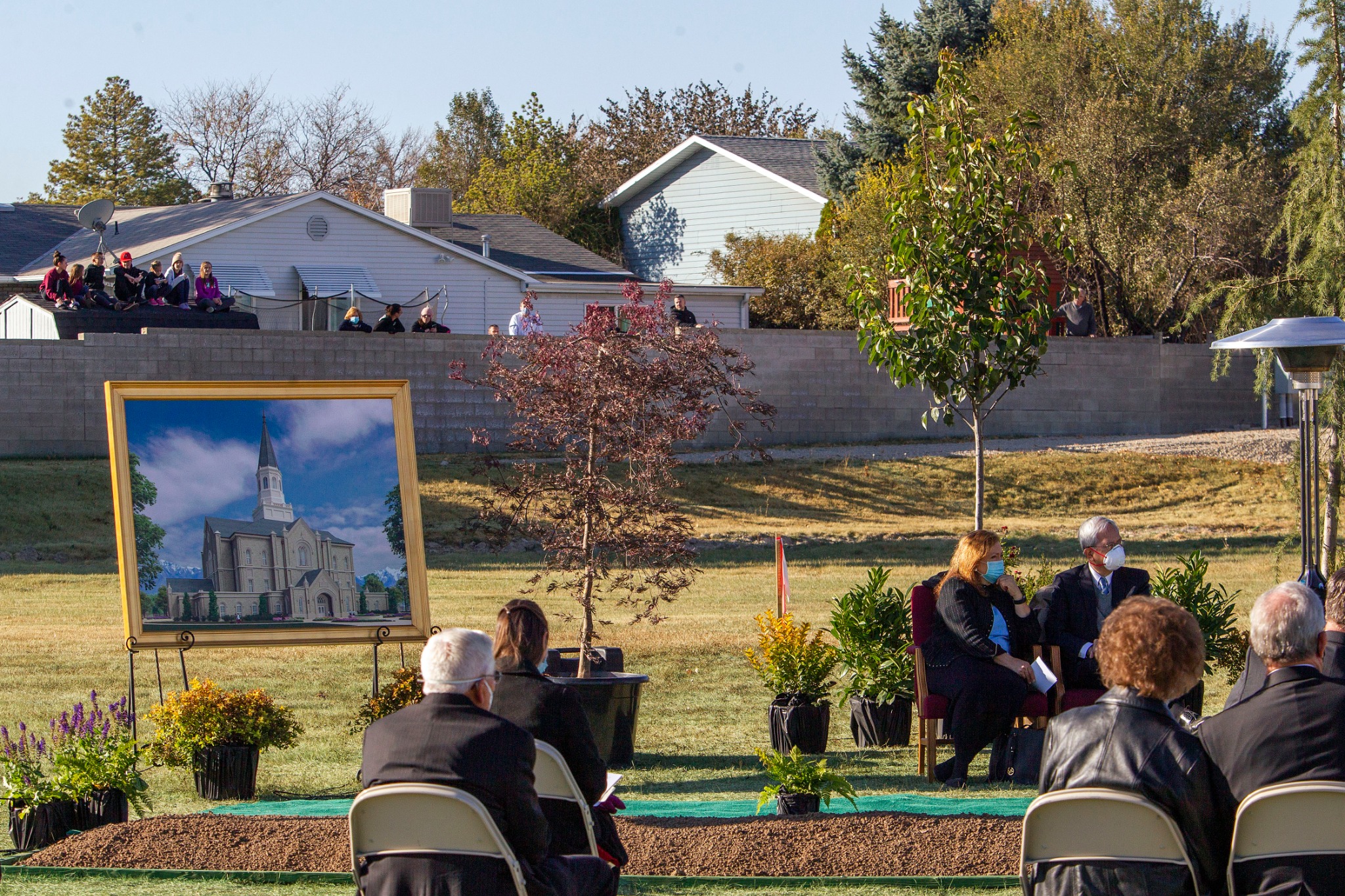 Neighbors look over the fence during the groundbreaking service for the Taylorsville Utah Temple on Saturday, October 31, 2020.
