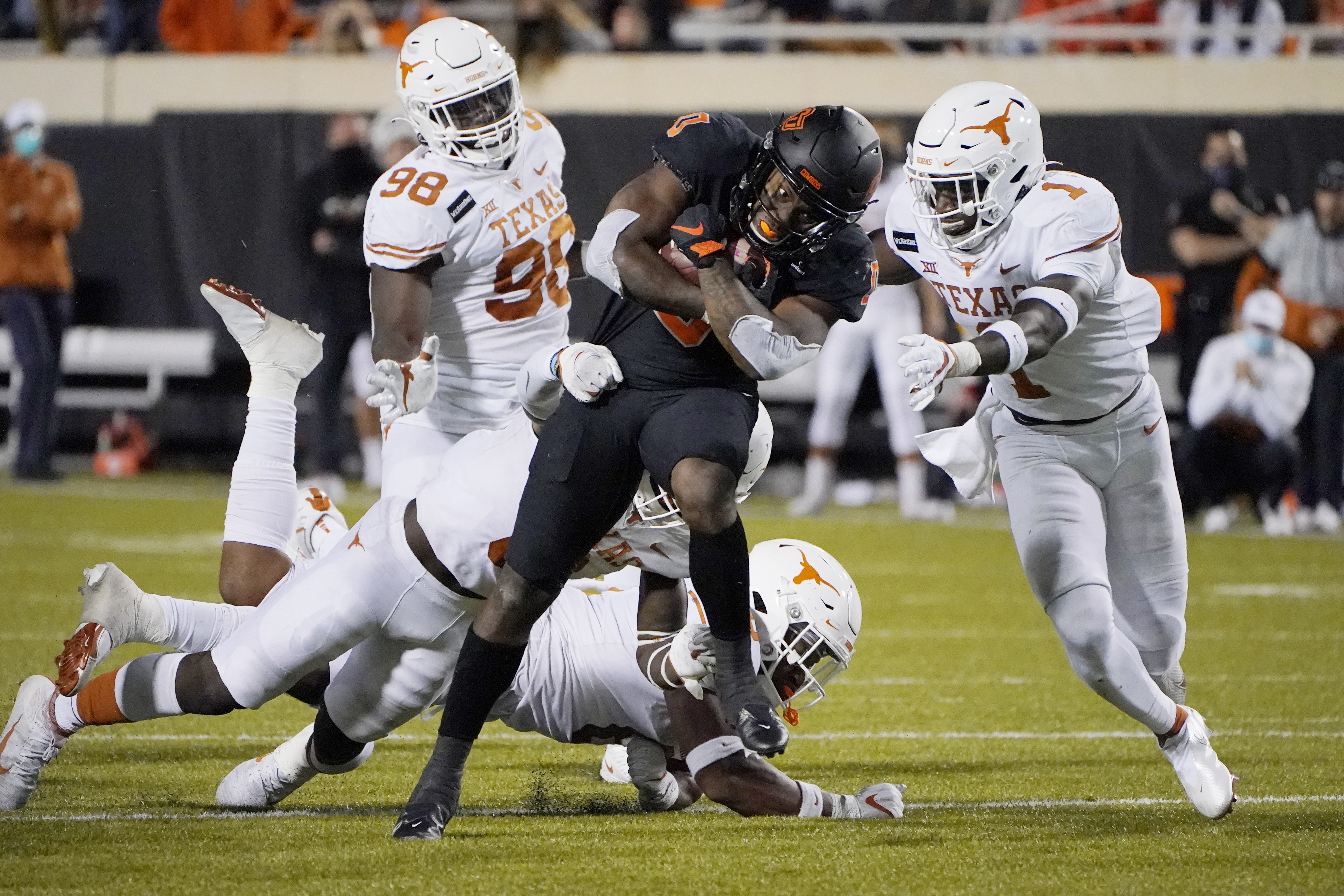 Texas defensive back Chris Adimora (1) moves in to tackle Oklahoma State running back LD Brown (0) in overtime of an NCAA college football game in Stillwater, Okla., Saturday, Oct. 31, 2020. (AP Photo/Sue Ogrocki) [Oct-31-2020]