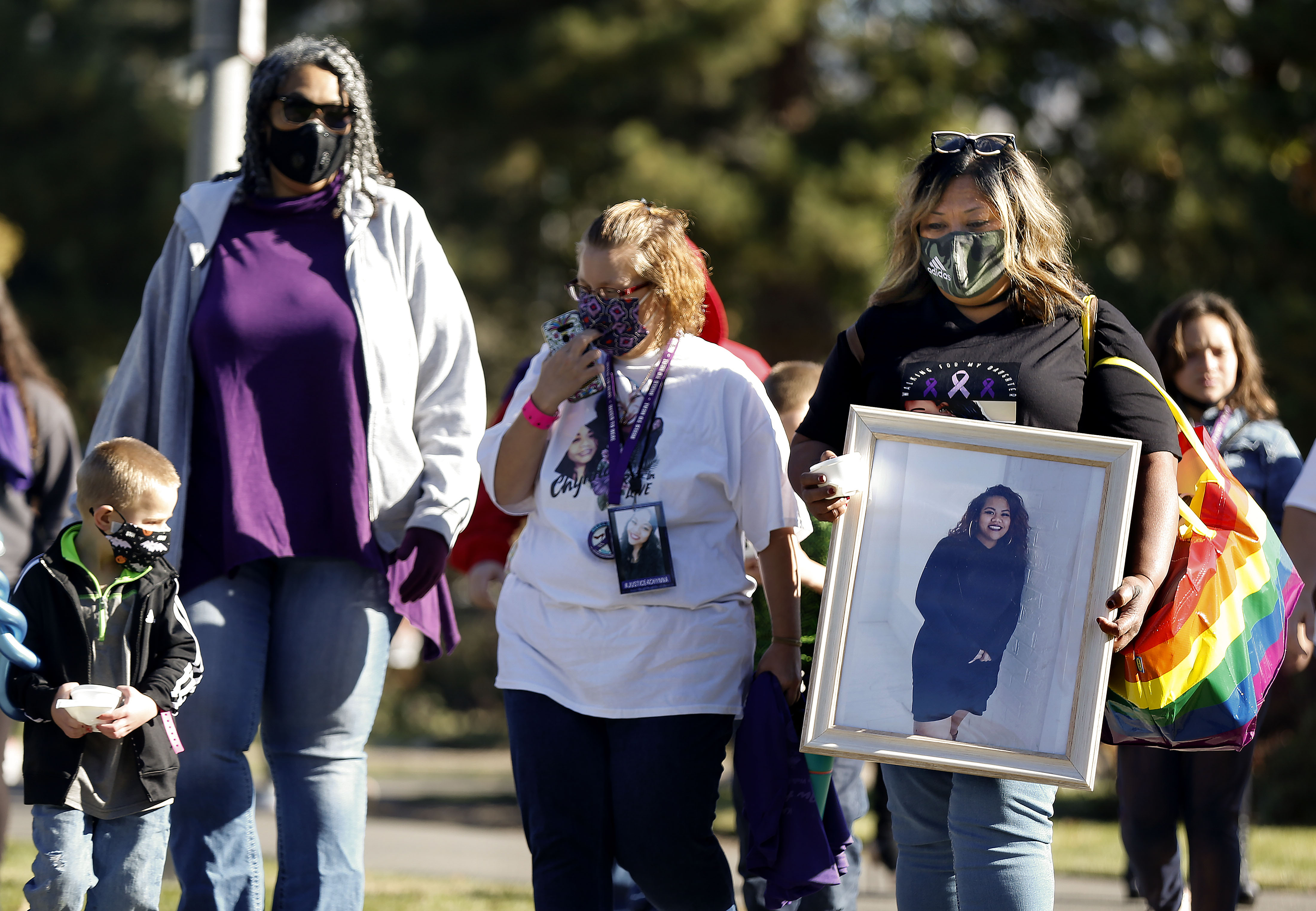 Terrie Toilolo, mother of Chynna Toilolo, carries a photo of Chynna while participating in the sixth annual In Heels 2 Heal domestic violence walk at the International Peace Gardens in Salt Lake City on Saturday, Oct. 31, 2020. Chynna Toilolo's body was found in Ogden Canyon in May, and in June her boyfriend was arrested and charged with murder.