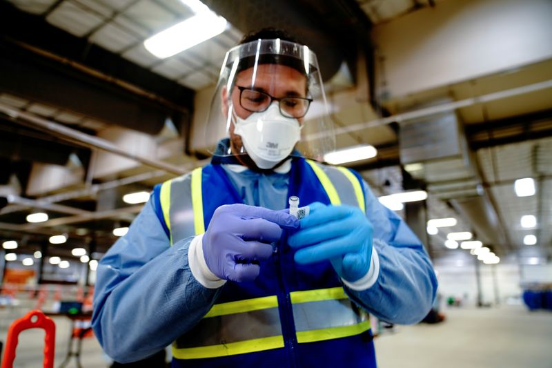 FILE PHOTO: Dr. Saulo Castellano labels a nasal swab sample inside a drive-thru COVID-19 testing site at the Alliant Energy Center complex, as the coronavirus disease outbreak continues in Madison, Wisconsin, U.S. October 31, 2020. REUTERS/Bing Guan