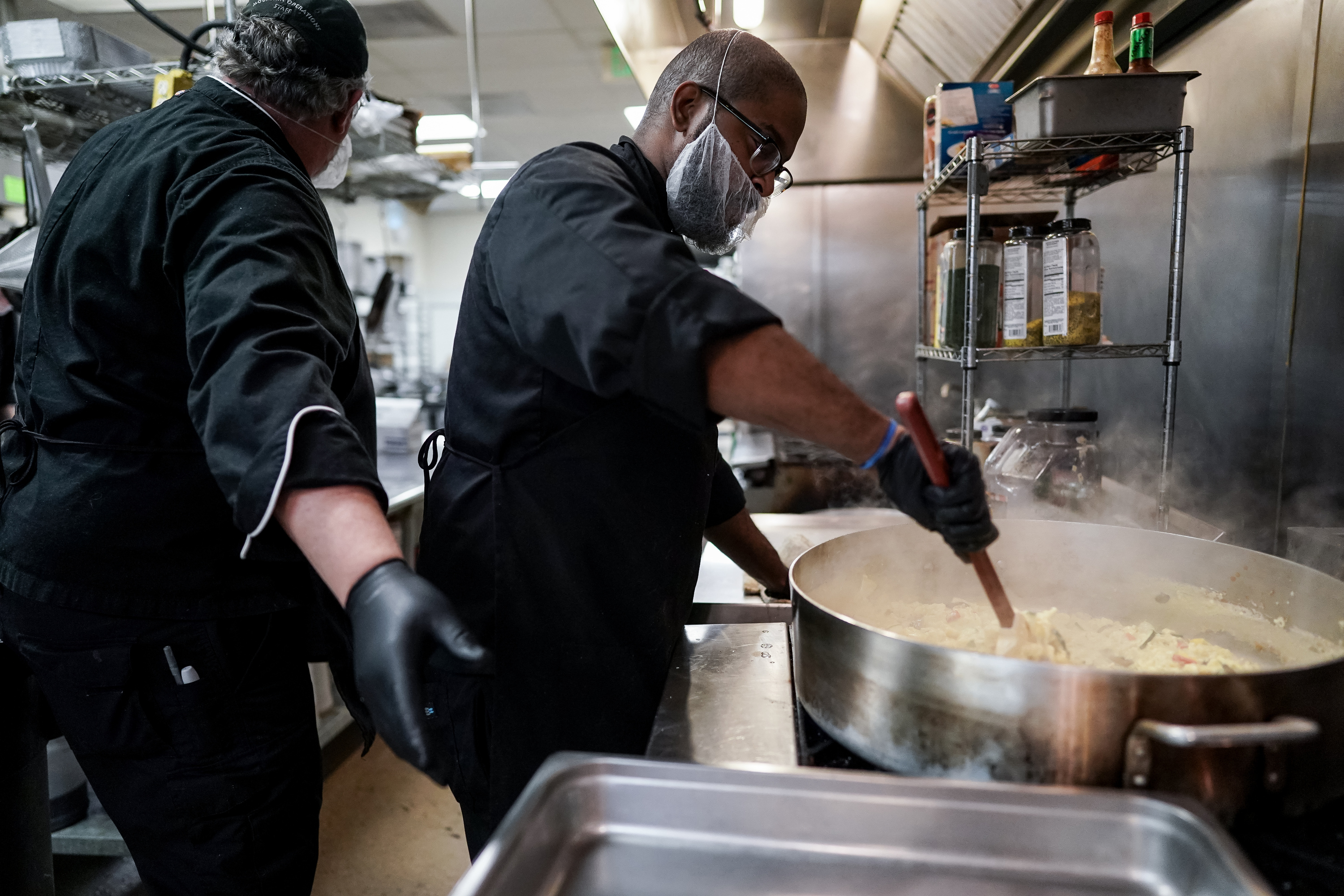 Joe LaRue, back, and Adam Reid work in the kitchen at Elizabeth's Catering in Salt Lake City on Thursday, March 19, 2020.