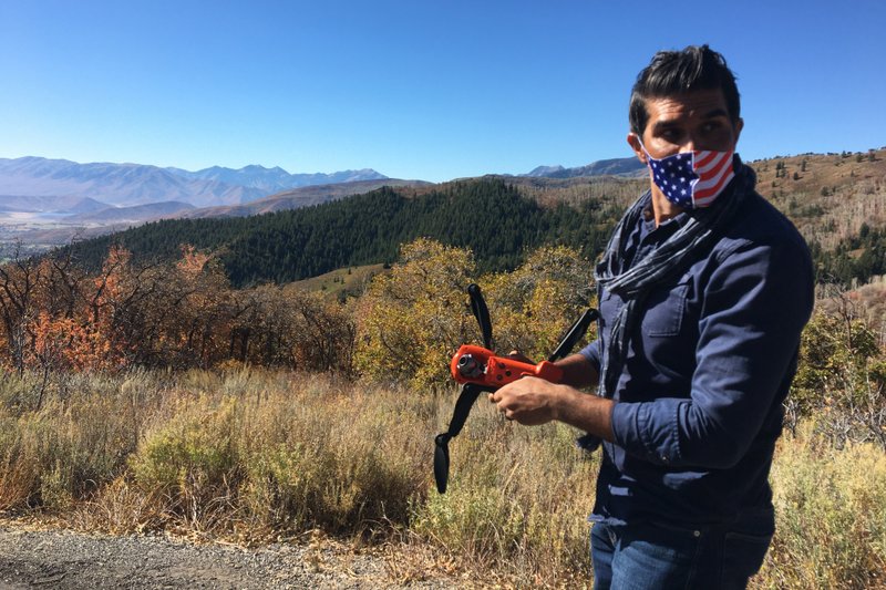 Jacob Narayan, 46, gets ready to fly his drone on a hilltop outside of Park City, Utah, on Sept. 30, 2020. Narayan has worked as a waiter for years, but the pandemic has made that unsustainable. Now he's shifting gears and working as a drone photographer. (Jon Reed/KUER-FM via AP)