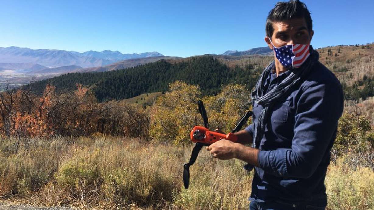 Jacob Narayan, 46, gets ready to fly his drone on a hilltop outside of Park City, Utah, on Sept. 30, 2020. Narayan has worked as a waiter for years, but the pandemic has made that unsustainable. Now he's shifting gears and working as a drone photographer. (Jon Reed/KUER-FM via AP)