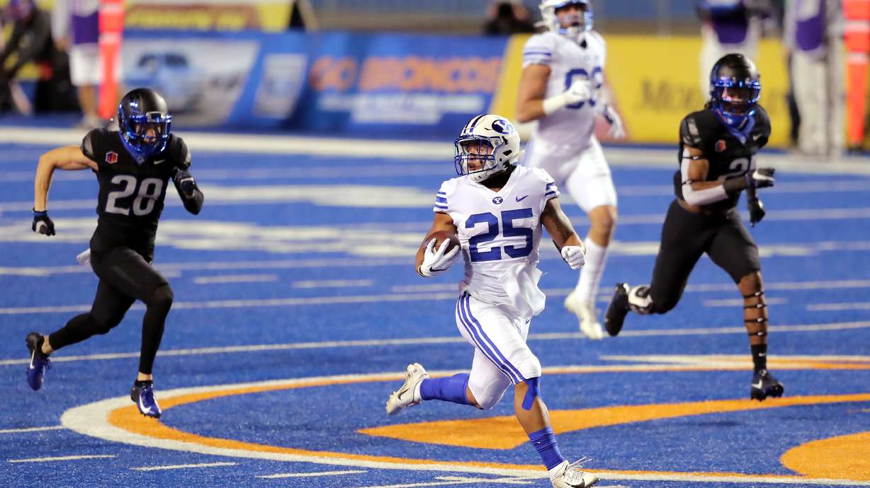 BYU running back Tyler Allgeier (25) looks back to see if he is in the clear as he runs for an 86-yard touchdown as BYU and Boise State play a college football game at Albertsons Stadium in Boise on Friday, Nov. 6, 2020.