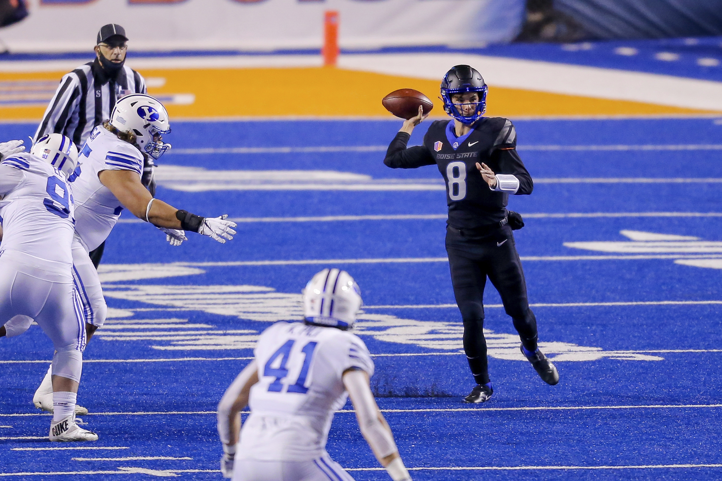 Boise State quarterback Cade Fennegan (8) looks for a receiver as the BYU defense closes in during the first half of an NCAA college football game Friday, Nov. 6, 2020, in Boise, Idaho.