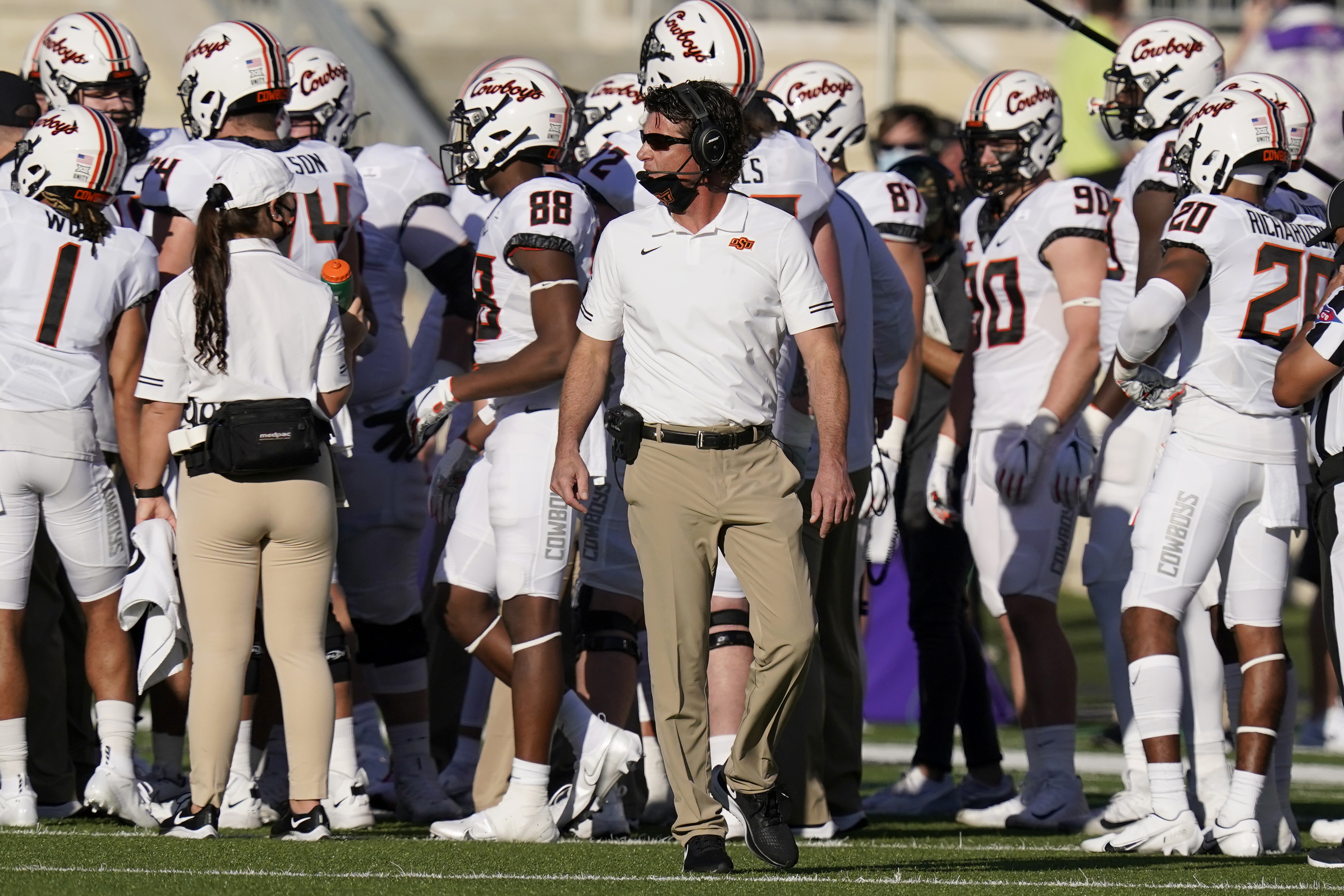 Oklahoma State head coach Mike Gundy, center, paces the sideline during the first half of an NCAA college football game against Kansas State in Manhattan, Kan., Saturday, Nov. 7, 2020.