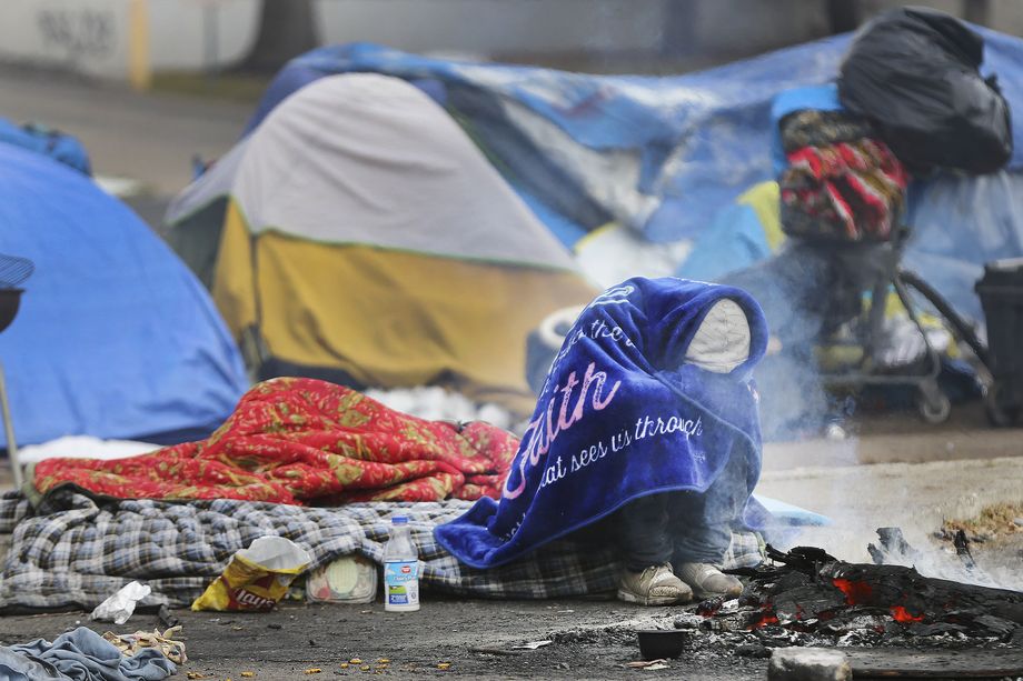 A homeless man bundles up near a fire on 700 South in Salt Lake City on Tuesday, Nov. 10, 2020. The Kem C. Gardner Policy Institute on Tuesday published a report identifying major problems within the state’s current homeless governance structure.