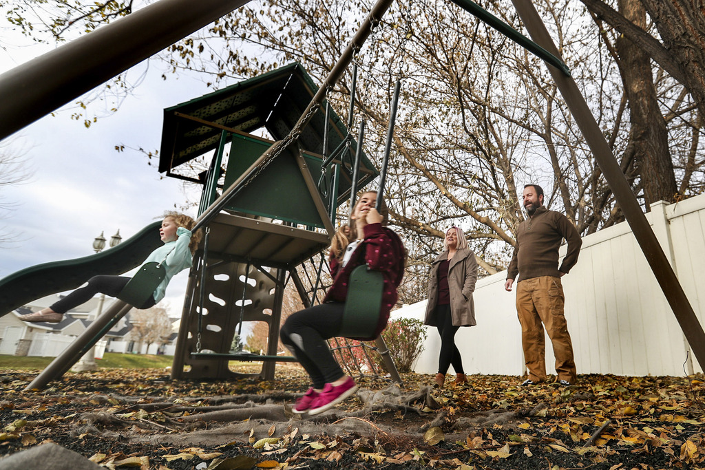 Sadie Hepworth, left, and her sister Penny swing in the backyard of their home in Layton as their parents, Jen and John Hepworth, watch on Tuesday, Nov. 10, 2020.