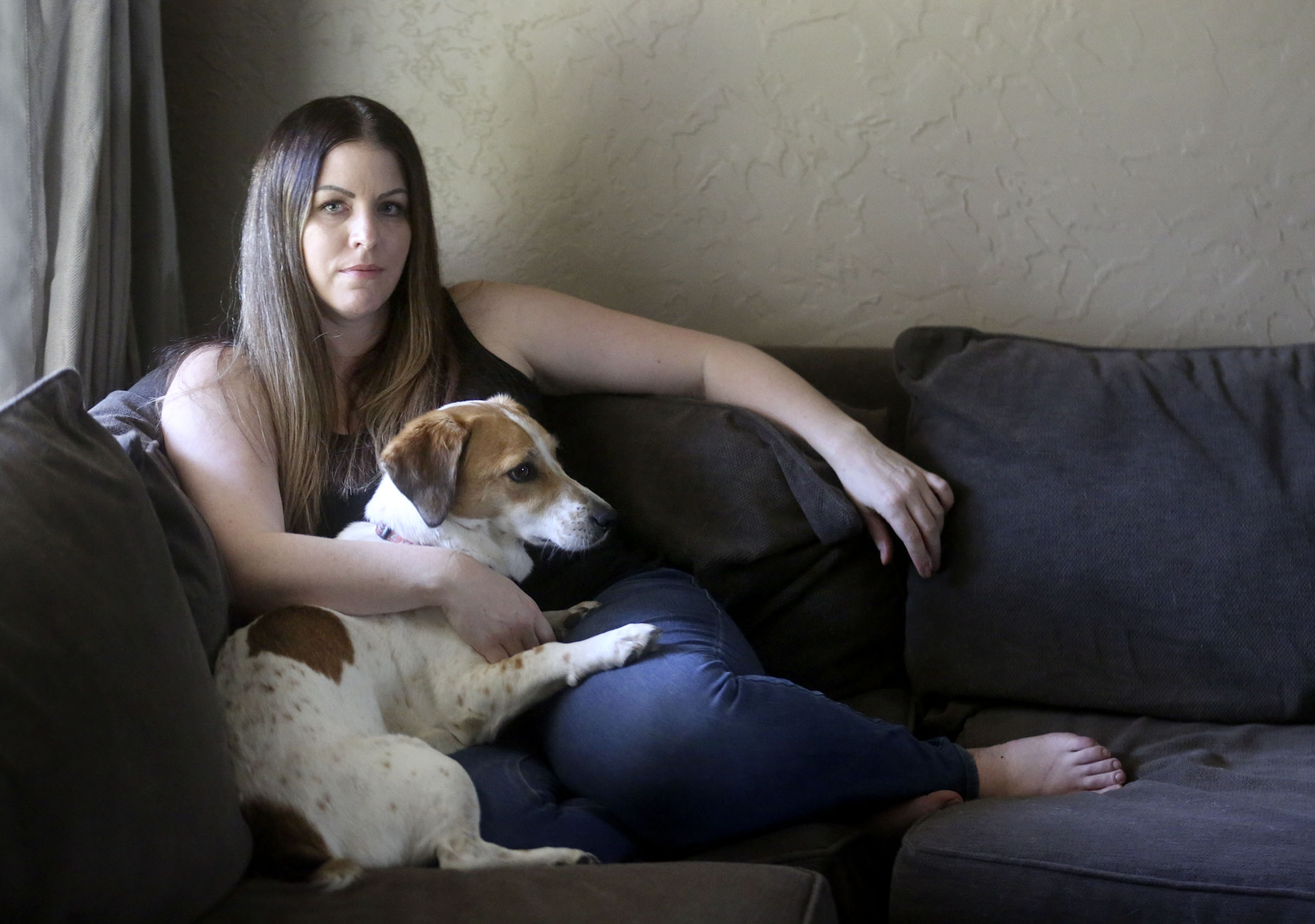 Lisa O'Brien poses for a portrait with her dog Jersey at home in Roy on Monday, Aug. 17, 2020. O'Brien has suffered blood clots, tachycardia and excessive fatigue in the five months since she was sick in early March with what she and her doctors believe was COVID-19.