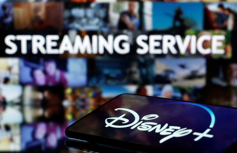 FILE PHOTO: A martphone with displayed "Disney" logo is seen in front of displayed "Streaming service" words in this illustration taken March 24, 2020. REUTERS/Dado Ruvic