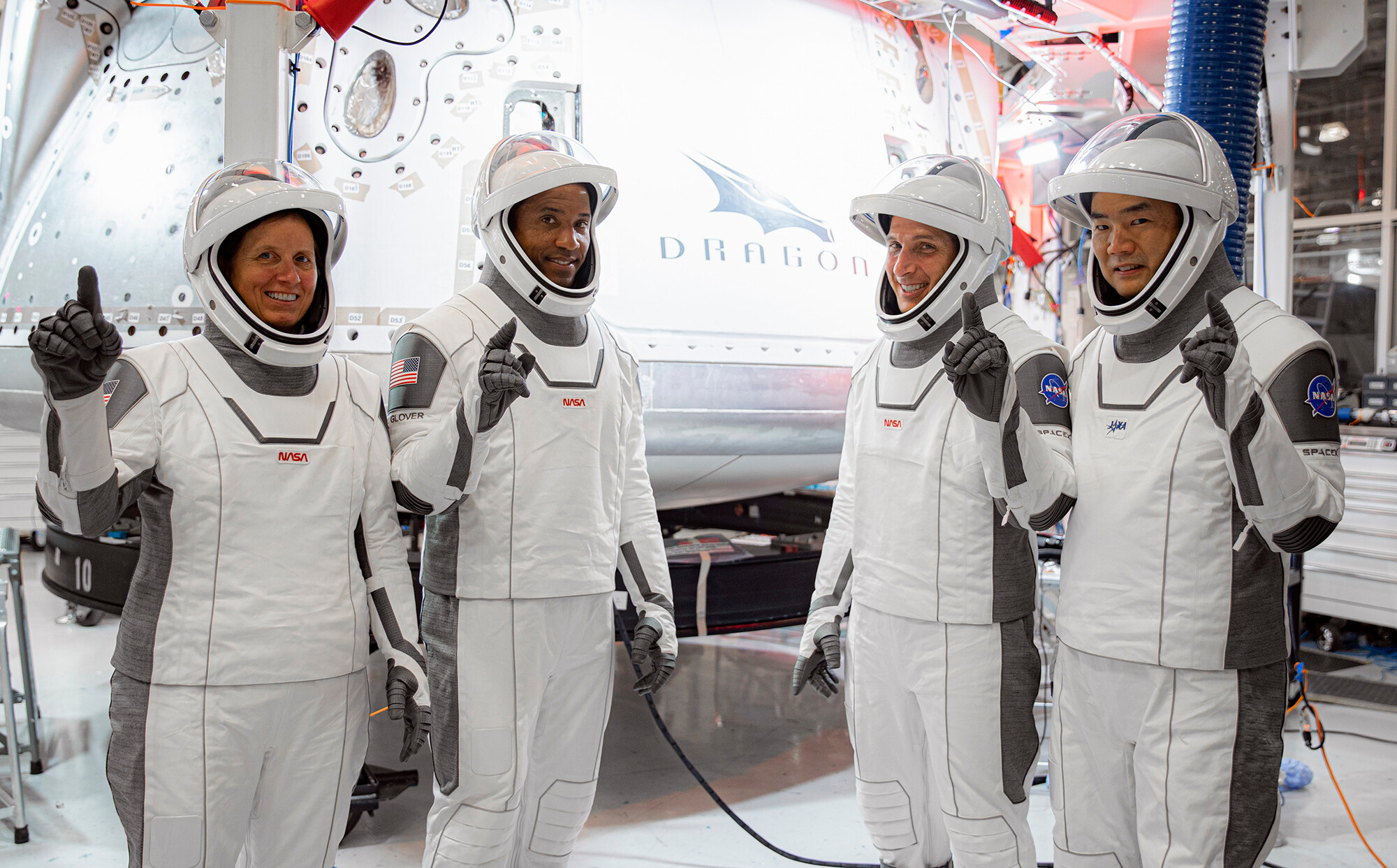 In this Thursday, Sept. 24, 2020, image released by SpaceX/NASA, NASA's SpaceX Crew-1 astronauts, from left, mission specialist Shannon Walker, pilot Victor Glover, and Crew Dragon commander Michael Hopkins, all NASA astronauts, and mission specialist Soichi Noguchi, Japan Aerospace Exploration Agency (JAXA) astronaut, gesture during crew equipment interface testing at SpaceX headquarters in Hawthorne, Calif. SpaceX's second astronaut flight is off until mid-November 2020 because red lacquer dripped into tiny vent holes in two rocket engines that now must be replaced.