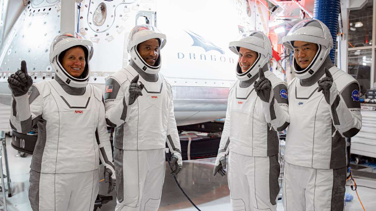 In this Thursday, Sept. 24, 2020, image released by SpaceX/NASA, NASA's SpaceX Crew-1 astronauts, from left, mission specialist Shannon Walker, pilot Victor Glover, and Crew Dragon commander Michael Hopkins, all NASA astronauts, and mission specialist Soichi Noguchi, Japan Aerospace Exploration Agency (JAXA) astronaut, gesture during crew equipment interface testing at SpaceX headquarters in Hawthorne, Calif. SpaceX's second astronaut flight is off until mid-November 2020 because red lacquer dripped into tiny vent holes in two rocket engines that now must be replaced.