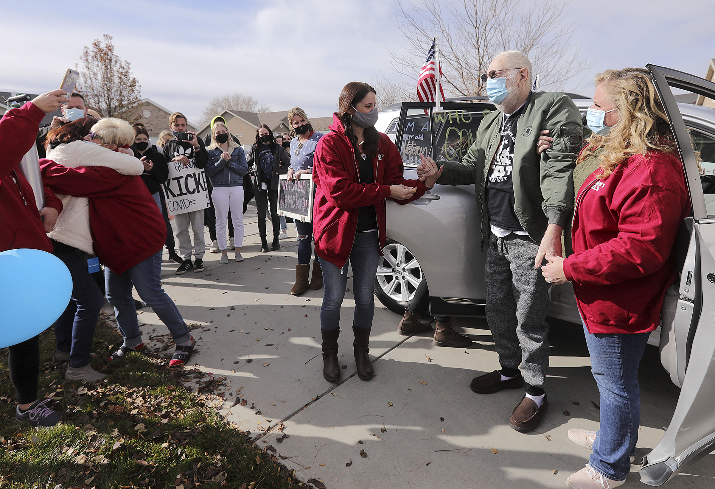 Vietnam veteran Warren Craig Eby, right center, is assisted by daughters Alissa Allen, left, and Lauren Cooper, right, during a welcome home celebration in Saratoga Springs on Friday, Nov. 13, 2020. Eby was hospitalized for seven weeks with COVID-19. At far left, Eby's wife, Sandra, hugs their niece Cindy Lampropoulos.