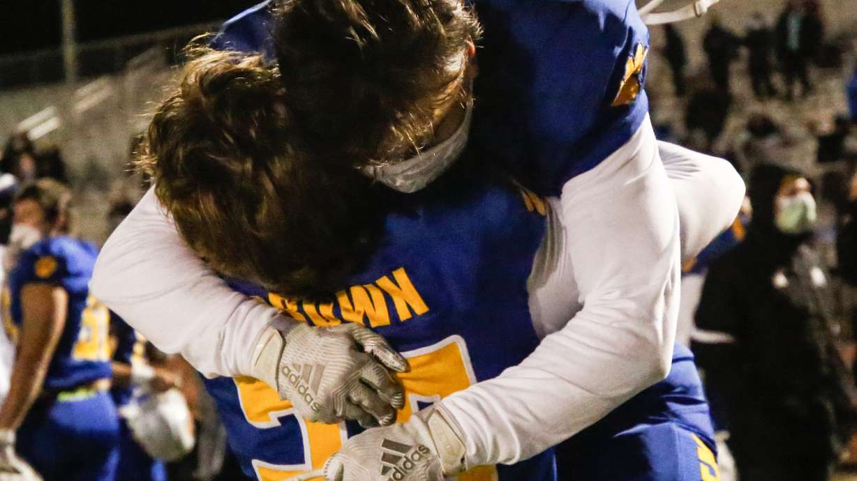 Orem's Kade Brown hugs Brayden Theurer (11) after a high school 5A state semifinal football game at Cedar Valley High School in Eagle Mountain on Friday, Nov. 13, 2020.