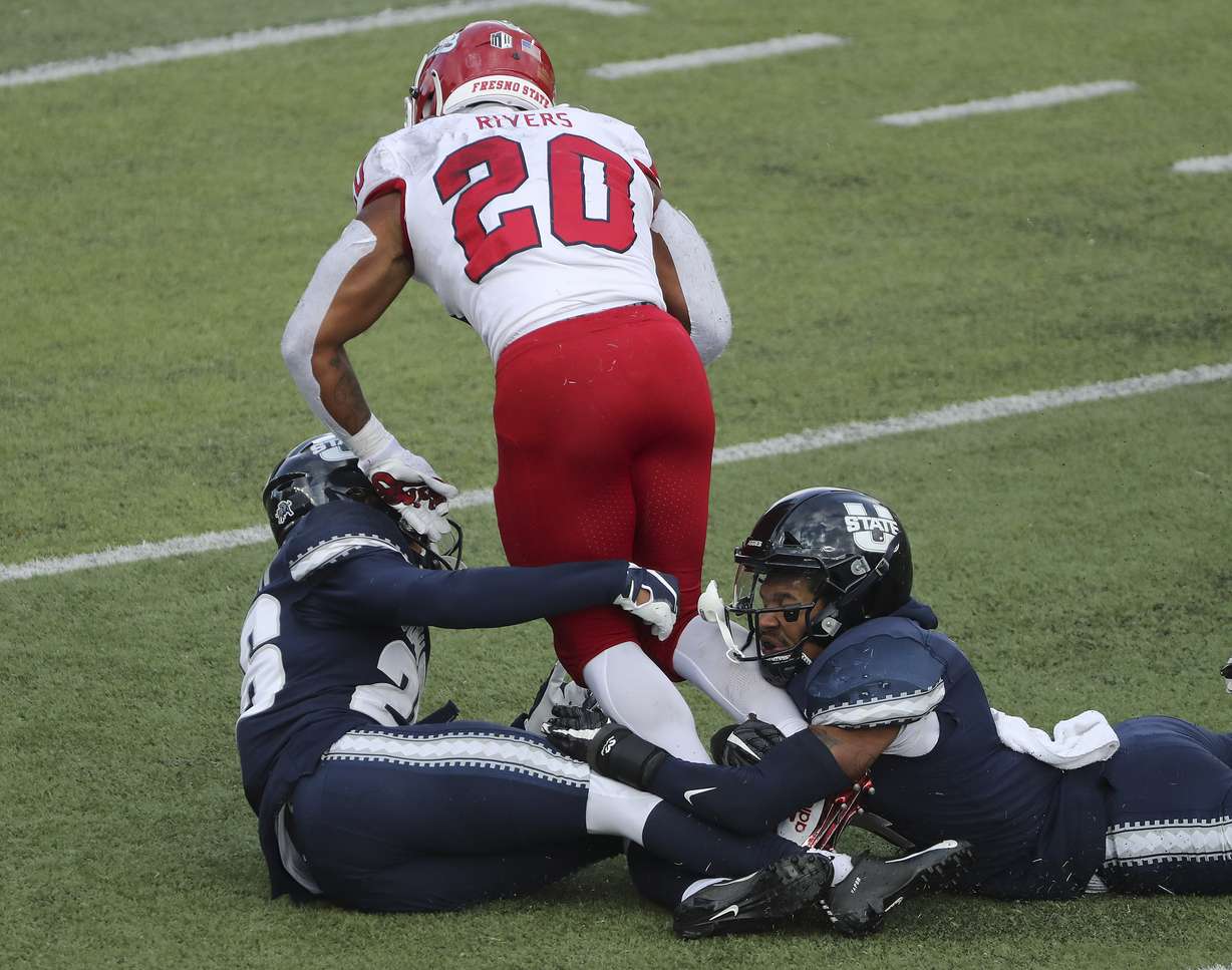 Utah State Aggies cornerback Jakob Robinson (26) tackles Fresno State Bulldogs running back Ronnie Rivers (20) in Logan on Saturday, Nov. 14, 2020.