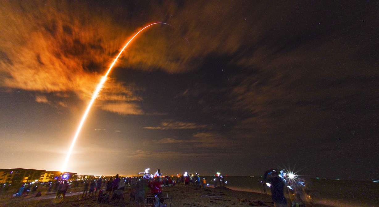 Crowds on the beach in Cape Canaveral, Fla., watch the launch of the SpaceX Falcon 9 Crew Dragon on its Crew-1 mission carrying four astronauts, Sunday, Nov. 15, 2020, in this 3 1/2-minute time exposure. The rocket was launched from Launch Complex 39A at Kennedy Space Center at 7:27 p.m. Sunday evening.