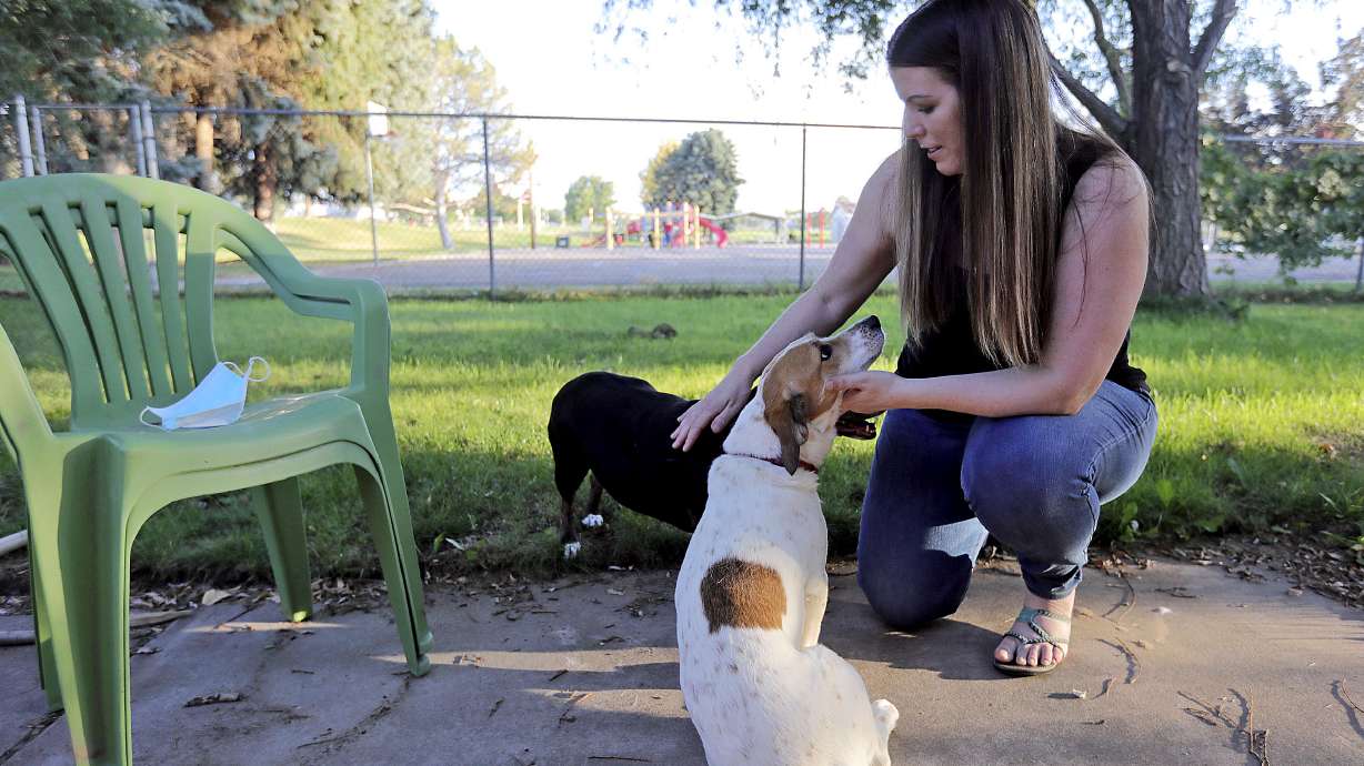 Lisa OâBrien plays with her dogs Jersey and Dottie outside of her home in Roy on Monday, Aug. 17, 2020. OâBrien has suffered blood clots, tachycardia and excessive fatigue in the five months since she was sick in early March with what she and her doctors believe was COVID-19.