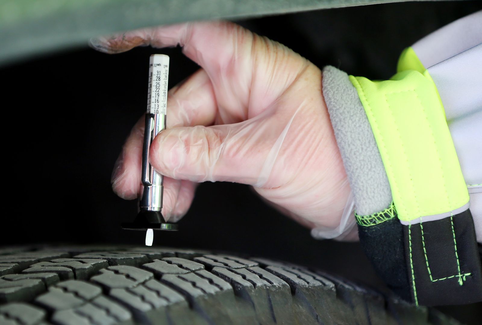 A worker measures the tread on a vehicle at the Utah Department of Transportation maintenance shed in Cottonwood Heights on Monday, Nov. 16, 2020, as UDOT and the Unified Police Department relaunch the Cottonwood canyons sticker program.
