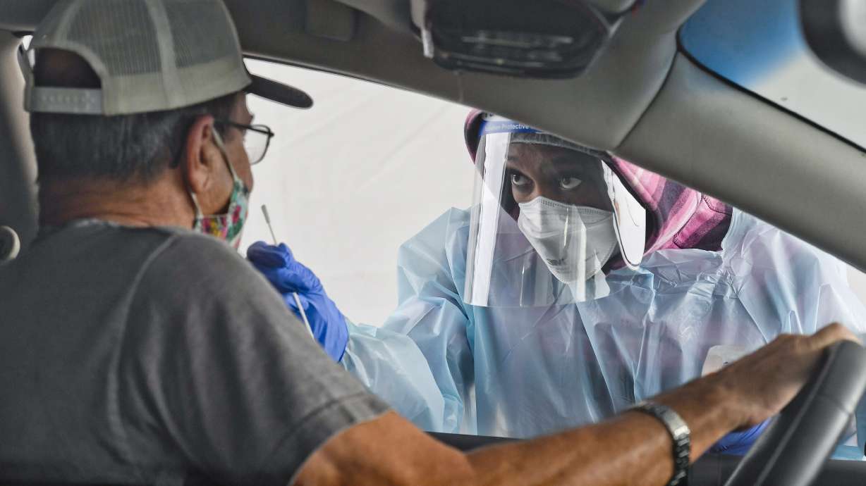 A man gets swabbed by CNA Keila Kelley at a free COVID-19 testing site on Front Street in Reading, PA outside FirstEnergy Stadium on October 13, 2020.