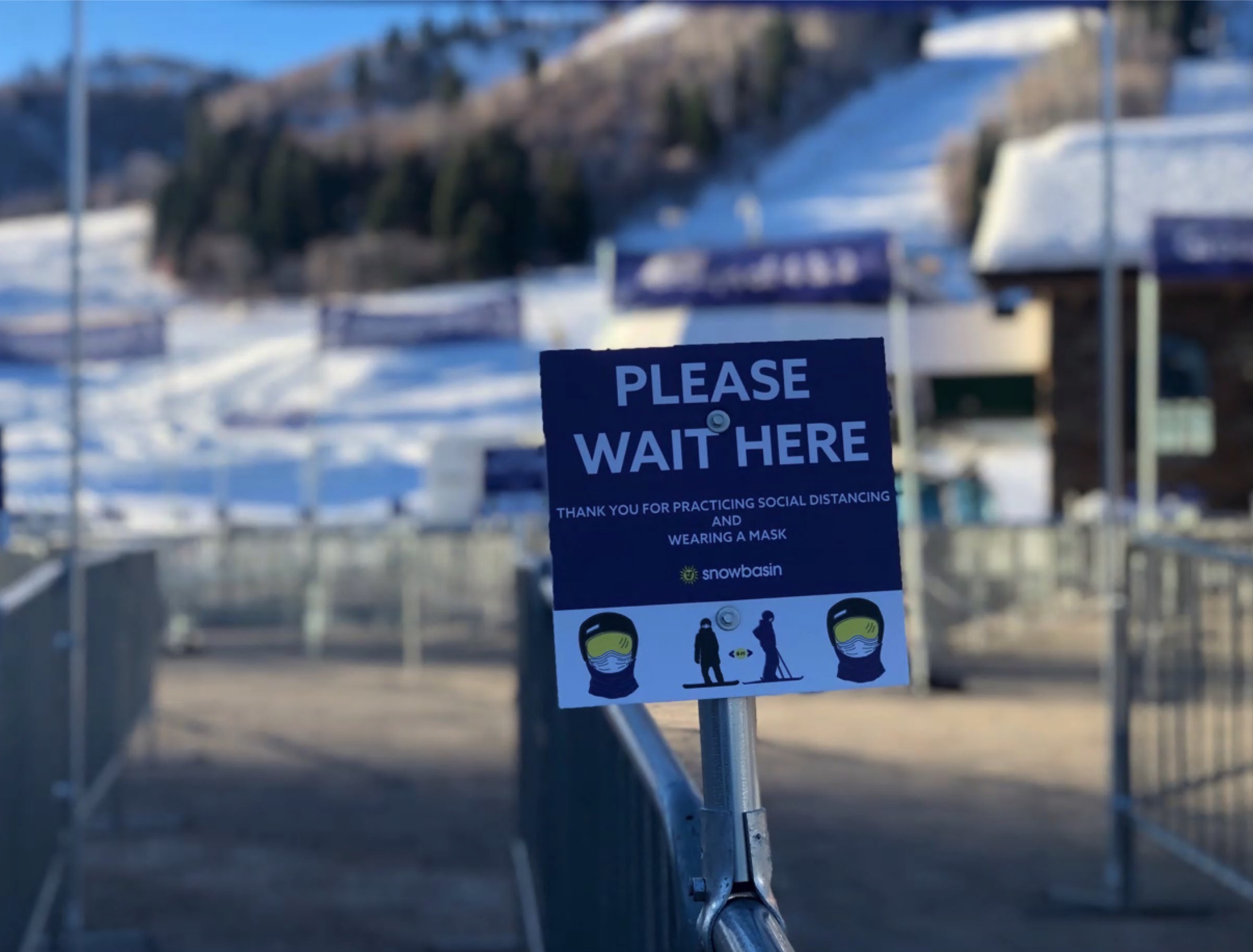 A photo of social distancing signage at lines in Snowbasin Resort.