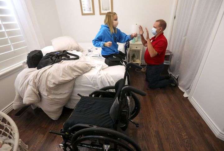 Sarah Frei reaches for a punch as Karl Ricks, a Community Nursing Services physical therapist, guides her to build strength and balance at her home in Syracuse on Tuesday, Nov. 17, 2020.