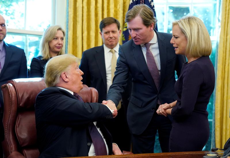 FILE PHOTO: U.S. President Donald Trump shakes hands with Chris Krebs, the director of the Cybersecurity and Infrastructure Security Agency (CISA) as DHS Secretary Kirstjen Nielsen (R) looks on after a signing ceremony for the Cybersecurity and Infrastructure Security Agency Act in the Oval Office of the White House in Washington, U.S. November 16, 2018.