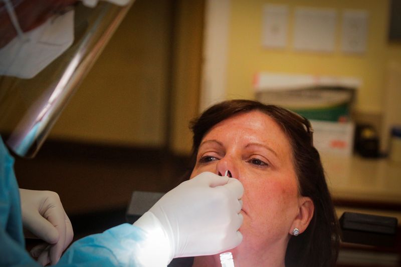FILE PHOTO: Dr. Vincent Carrao swabs a patient's nose for the coronavirus disease (COVID-19) test at Palisades Oral Surgery, in Fort Lee, New Jersey, U.S., June 15, 2020. REUTERS/Brendan McDermid