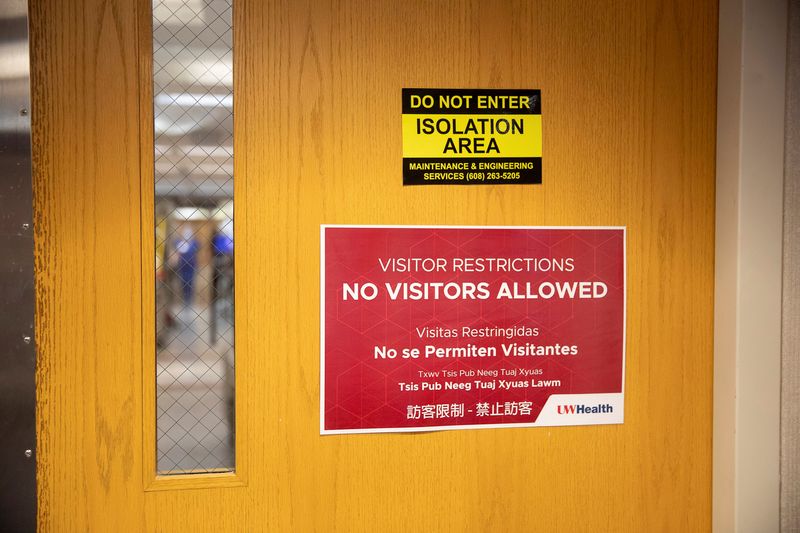Signage hangs on entry doors to a hospital wing housing coronavirus disease (COVID-19) patients at UW Health University Hospital in Madison, Wisconsin, U.S. November 18, 2020.  REUTERS/Daniel Acker