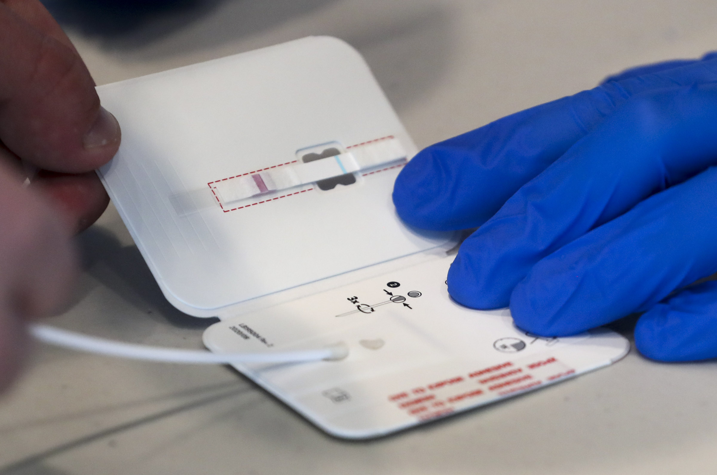 A University of Utah student places a swab in a testing card after taking a rapid COVID-19 test at Rice-Eccles Stadium in Salt Lake City on Wednesday, Nov. 11, 2020. The university has launched an initiative to test 32,000 students for COVID-19 before the Thanksgiving break.