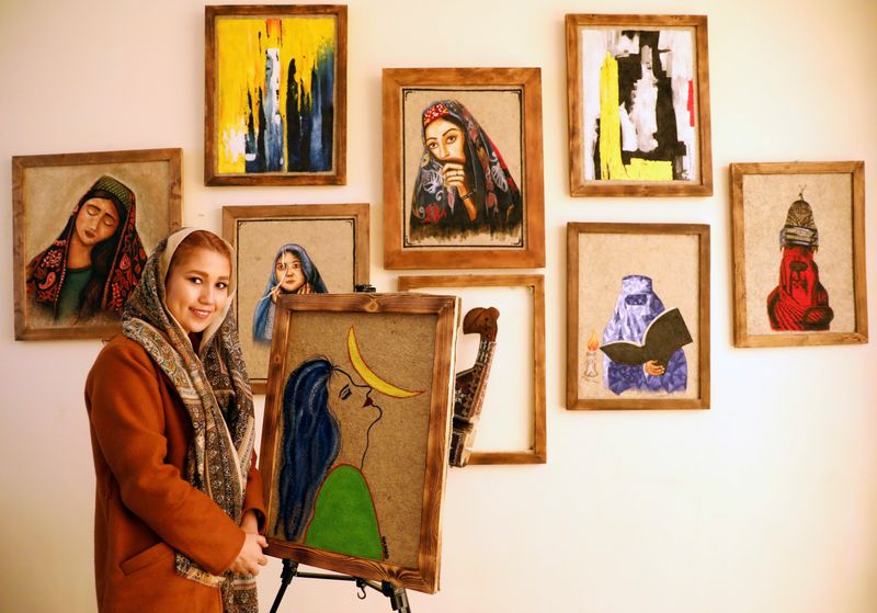 Afghan artist Faiqa Sultani poses next to her painting at the Namad Gallery in Kabul, Afghanistan November 9, 2020.   REUTERS/Mohammad Ismail