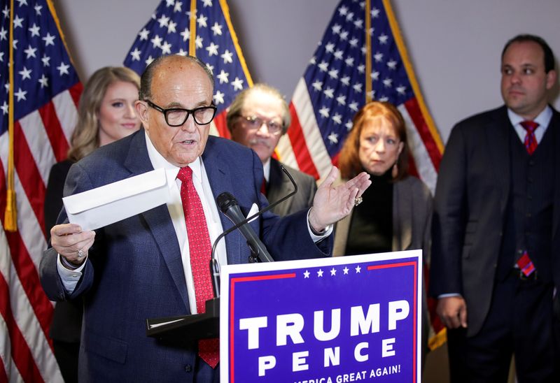 FILE PHOTO: Former New York City Mayor Rudy Giuliani, personal attorney to U.S. President Donald Trump, holds what he identified as a replica mail-in ballot as he speaks about the 2020 U.S. presidential election results during a news conference in Washington, U.S., Nov. 19, 2020. REUTERS/Jonathan Ernst/File Photo